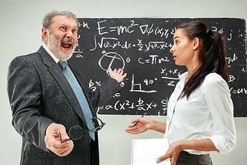 Image showing Male professor and young woman against chalkboard in classroom