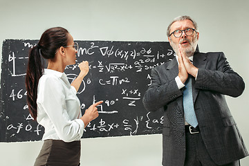 Image showing Male professor and young woman against chalkboard in classroom