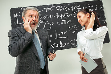 Image showing Male professor and young woman against chalkboard in classroom