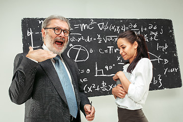 Image showing Male professor and young woman against chalkboard in classroom