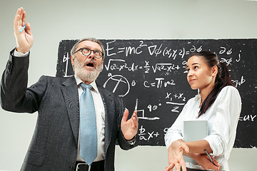 Image showing Male professor and young woman against chalkboard in classroom