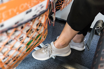 Image showing Female passenger with lack of leg space on long commercial airplane flight. Focus on casual sporty sneakers