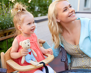 Image showing mother and baby daughter at cafe looking up