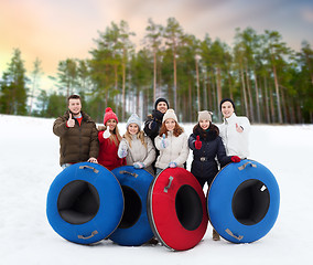 Image showing happy friends with snow tubes outdoors in winter