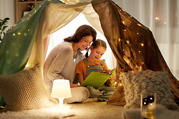 Image showing happy family reading book in kids tent at home