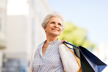 Image showing senior woman with shopping bags in city