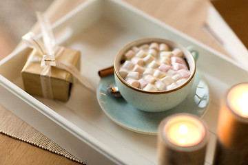 Image showing hot chocolate, christmas gift and candles on table