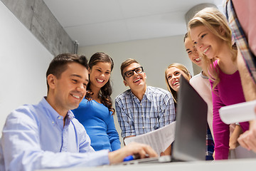 Image showing students and teacher with papers and laptop