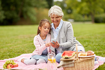 Image showing grandmother and granddaughter with cell at park