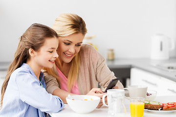 Image showing family with smartphone having breakfast at home