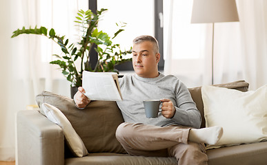 Image showing man reading newspaper and drinking coffee at home