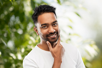 Image showing smiling indian man touching his beard