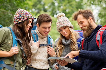 Image showing friends or travelers hiking with backpacks and map