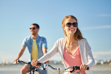 Image showing happy young couple riding bicycles at seaside