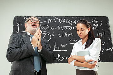 Image showing Male professor and young woman against chalkboard in classroom