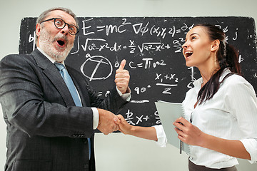 Image showing Male professor and young woman against chalkboard in classroom