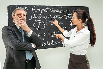 Image showing Male professor and young woman against chalkboard in classroom