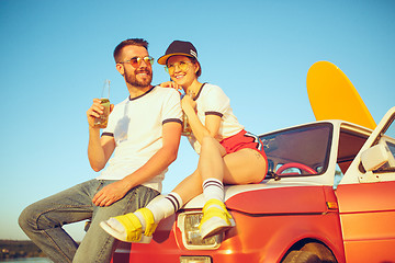 Image showing Couple resting on the beach on a summer day near river. Love, happy family, vacation