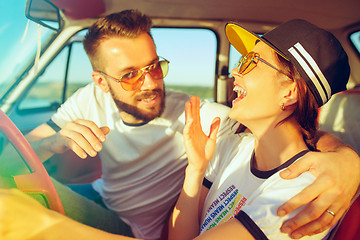 Image showing Laughing romantic couple sitting in car while out on a road trip at summer day