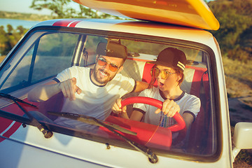 Image showing Laughing romantic couple sitting in car while out on a road trip at summer day