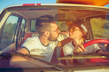 Image showing Laughing romantic couple sitting in car while out on a road trip at summer day