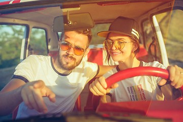 Image showing Laughing romantic couple sitting in car while out on a road trip at summer day