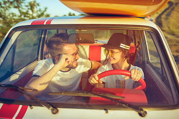 Image showing Laughing romantic couple sitting in car while out on a road trip at summer day