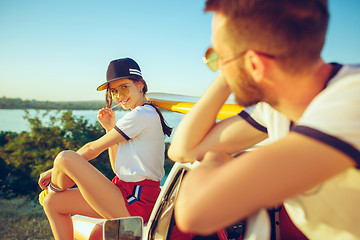 Image showing Couple sitting and resting on the beach on a summer day near river