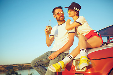 Image showing Couple resting on the beach on a summer day near river. Love, happy family, vacation