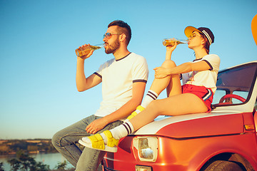 Image showing Couple resting on the beach on a summer day near river. Love, happy family, vacation