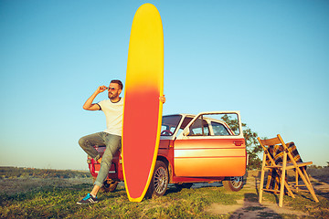 Image showing The surfboard, car, man.