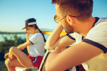 Image showing Couple sitting and resting on the beach on a summer day near river