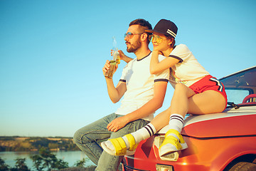 Image showing Couple resting on the beach on a summer day near river. Love, happy family, vacation