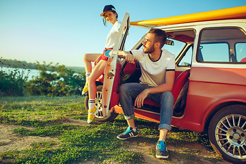 Image showing Couple sitting and resting on the beach on a summer day near river