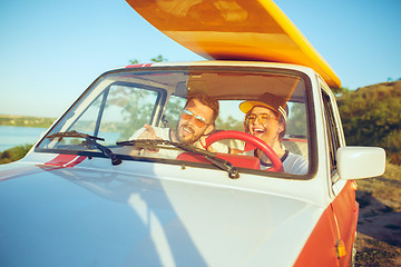 Image showing Laughing romantic couple sitting in car while out on a road trip at summer day