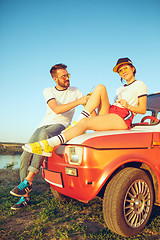 Image showing Couple resting on the beach on a summer day near river. Love, happy family, vacation