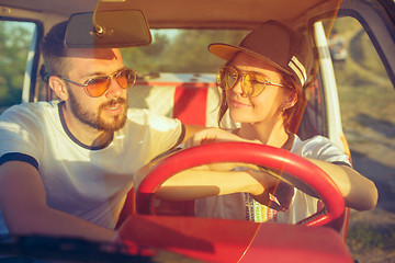 Image showing Laughing romantic couple sitting in car while out on a road trip at summer day