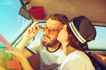 Image showing Laughing romantic couple sitting in car while out on a road trip at summer day