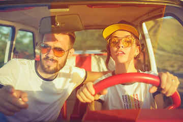 Image showing Laughing romantic couple sitting in car while out on a road trip at summer day