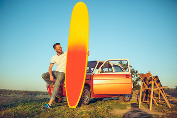 Image showing The surfboard, car, man.