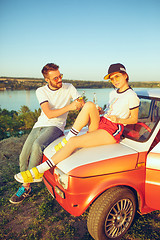 Image showing Couple resting on the beach on a summer day near river. Love, happy family, vacation