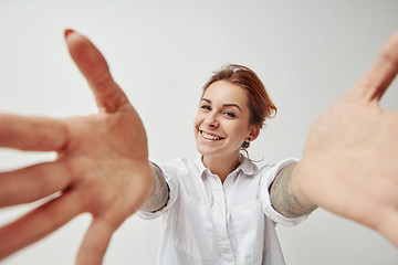 Image showing Young woman smiling with her arms open on white background