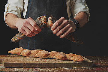 Image showing hands men break the baguette