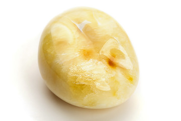 Image showing Natural amber. A piece of yellow opaque natural amber on white background.