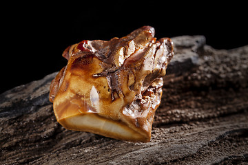 Image showing Natural amber. A piece of brownish opaque natural amber on white background.