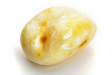 Image showing Natural amber. A piece of yellow opaque natural amber on white background.