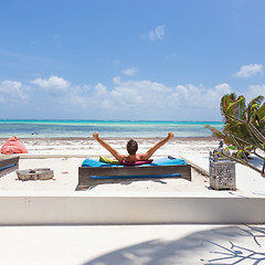 Image showing Relaxed man in luxury lounger, arms rised, enjoying summer vacations on beautiful beach.