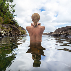 Image showing Naked woman bathing and relaxing in natural swimming pool.