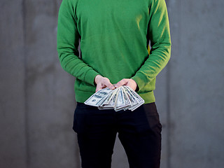 Image showing business man displaying a spread of american dollar cash money