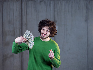 Image showing business man displaying a spread of american dollar cash money